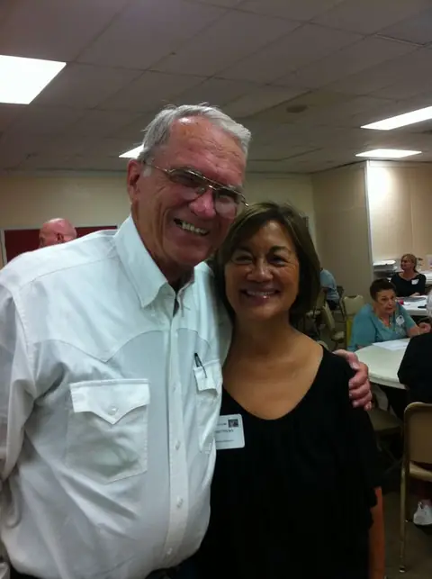 A smiling man and woman posing together at an indoor gathering