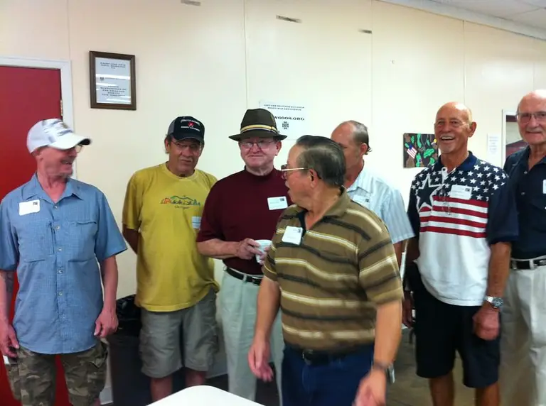 A group of men in casual shirts standing together and talking